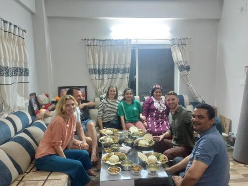 a group of people sitting in a living room eating food at Nishan Apartments -Lakeside in Pokhara
