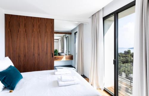 a bedroom with a bed and a large window at Penthouse Les Oliviers in Porto-Vecchio