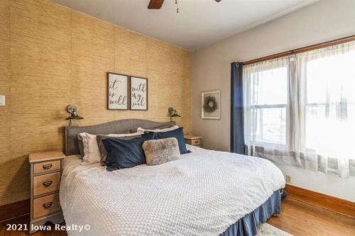 Un dormitorio con una cama grande y una ventana en Bright 4br Bungalow Sleep 12 Near Des Moines & I80, en Stuart