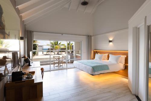 a bedroom with a bed and a balcony at Pearl Beach Hotel in Saint-Jean