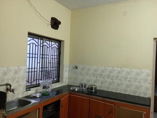 eine Küche mit einem Waschbecken und einem Fenster in der Unterkunft Ahobila Delux Homes in Tiruchchirāppalli