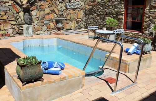 a swimming pool with a fountain in front of a building at Barrydale Karoo - BOUTIQUE HOTEL in Barrydale