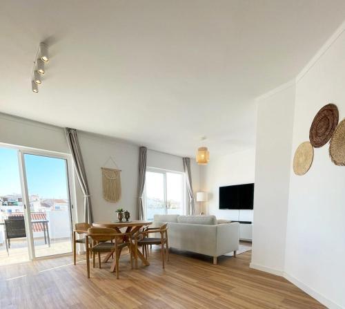 uma sala de estar com uma mesa e um sofá em Sun Waves Beach Apartment em Portimão