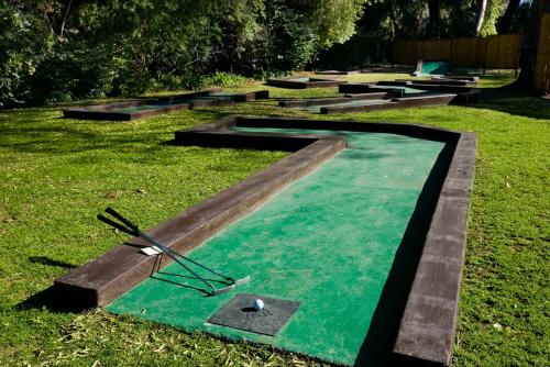 a pool with a clock in the grass at Oudtshoorn Inn Hotel in Oudtshoorn