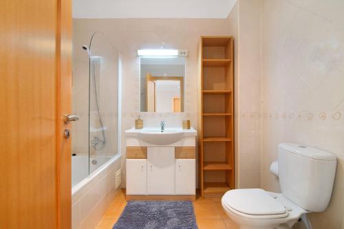 a bathroom with a white toilet and a sink at 17f arcos in Armação de Pêra