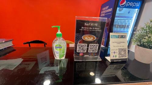 a glass table with a bottle of detergent and other items at Saltstayz Sector 39- Near Rajiv Chowk & Sohna Road in Gurgaon