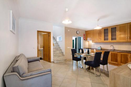 a living room and kitchen with a couch and a table at Casa Mar-a-vila in Olhão