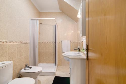 a bathroom with a toilet sink and a shower at Casa Mar-a-vila in Olhão