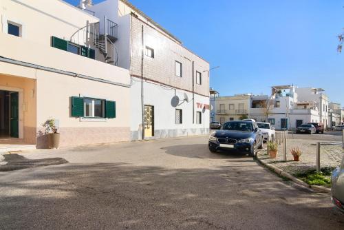 a car parked in a parking lot next to a building at Casa Mar-a-vila in Olhão