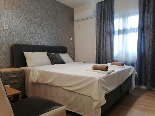 - une chambre avec un grand lit et une fenêtre dans l'établissement Apartmani Mia, à Kraljevo