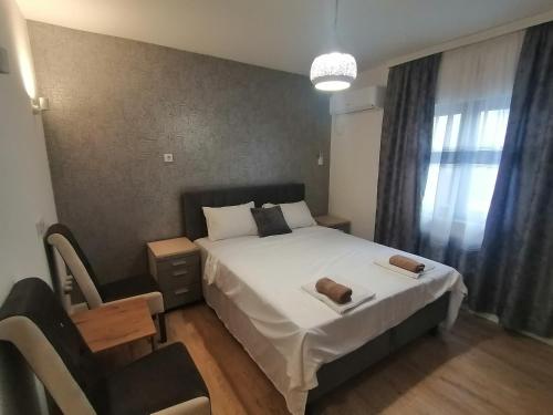 a small bedroom with a bed and a chair at Apartmani Mia in Kraljevo