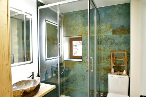 een badkamer met een wastafel en een glazen douche bij LA CASETA DELS HEROIS in Puigcerdà