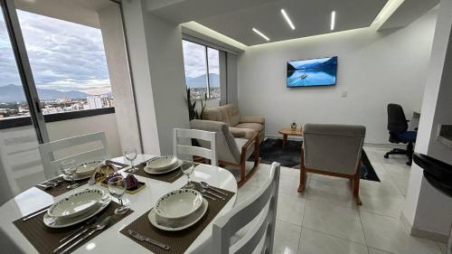 a dining room with a table and chairs and a living room at Lujoso y Confortable Apartamento in Cúcuta