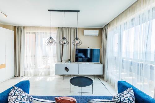 a living room with a blue couch and a tv at St. Panteleimon Beach Hotel in Nesebar