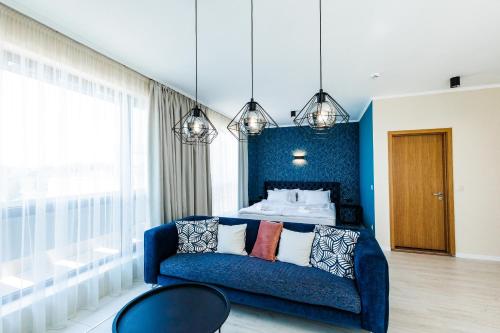 a blue bedroom with a bed and a blue couch at St. Panteleimon Beach Hotel in Nesebar