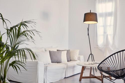 a white living room with a white couch and a table at Pietra e Mare - Mykonos Moments in Kalo Livadi