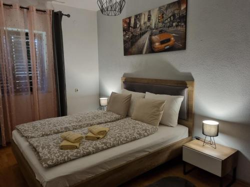a bedroom with a bed with two towels on it at Apartments Neppa in Postira