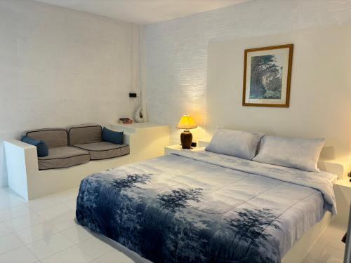 a bedroom with a bed and a couch at Baansuan Suksangob Farm Stay in Trang