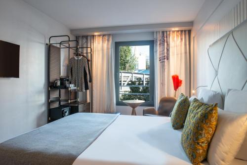 a bedroom with a large white bed and a window at Le Parisis - Paris Tour Eiffel in Paris