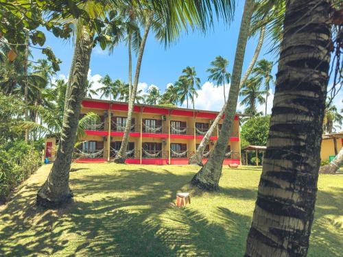 a building with palm trees in front of it at Igarakuê Flat in Japaratinga