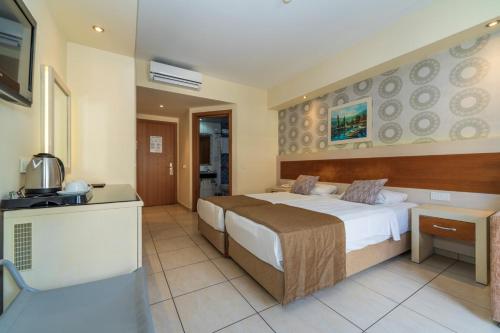 a hotel room with a bed and a kitchen at Montebello Resort Hotel - All Inclusive in Oludeniz