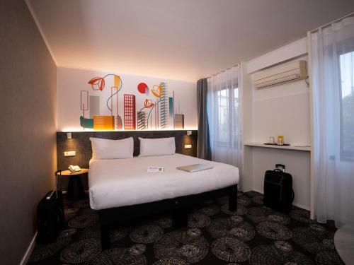 a hotel room with a bed with a white bedspread at ibis Styles Pitesti Arges in Piteşti