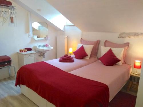 1 dormitorio con 2 camas con sábanas rojas y blancas en Au bord de la Dronne, en Bonnes