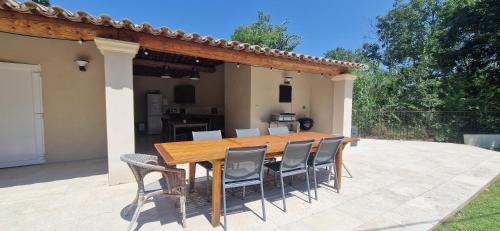 a wooden table and chairs on a patio at La Bastide des Arts in Saumane-de-Vaucluse