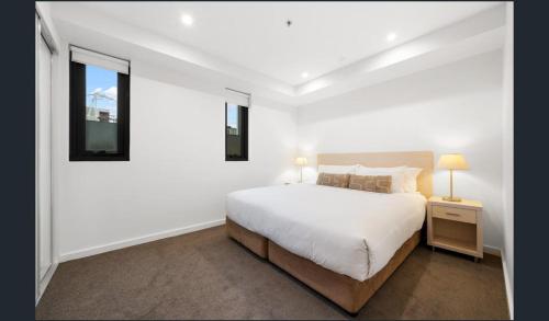 a white bedroom with a bed and a window at Hi 5 star Adelaide City Luxury Oasis in Adelaide