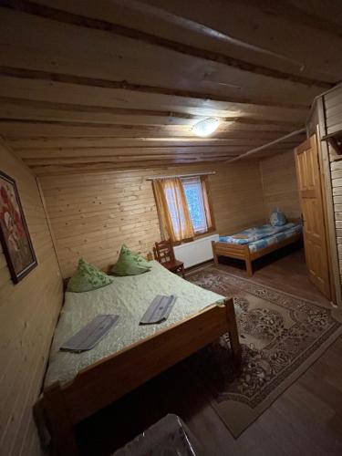 a bedroom with a bed in a log cabin at Калина in Dragobrat