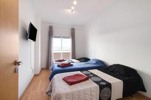 - 2 lits dans une petite chambre avec fenêtre dans l'établissement Holiday Apartment Portimão, à Portimão