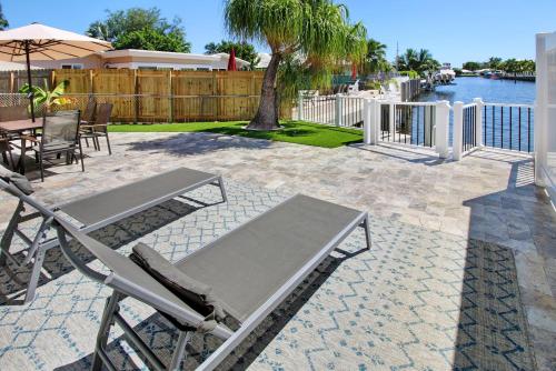 eine Terrasse mit Stühlen, einem Sonnenschirm und einem Tisch in der Unterkunft The Waterman's Retreat Unit N in Fort Lauderdale