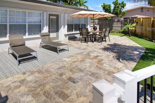 a patio with chairs and a table with an umbrella at The Waterman's Retreat Unit N in Fort Lauderdale