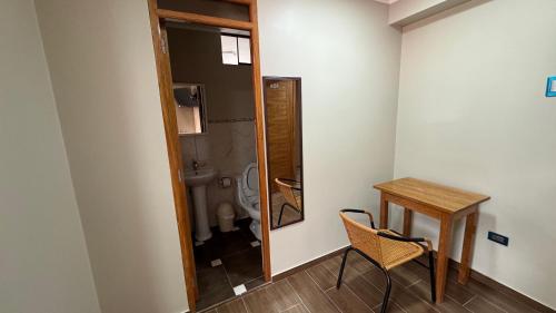 uma casa de banho com um WC, uma mesa e um espelho. em Hostal Tinkoj em Chavín de Huantar