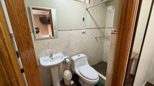 a small bathroom with a toilet and a sink at Hostal Tinkoj in Chavín de Huantar