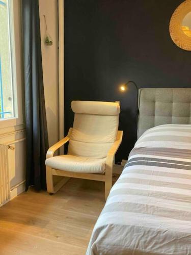 - une chambre avec une chaise à côté d'un lit dans l'établissement Studio hypercentre Quai de Seine, à Rouen