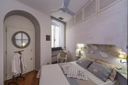 a white bedroom with a bed and a mirror at Portofino Above the Sea in Portofino