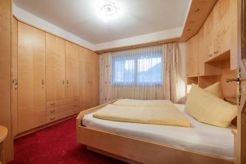 Un dormitorio con una cama grande y una ventana en Landhaus Hofer, en Neustift im Stubaital