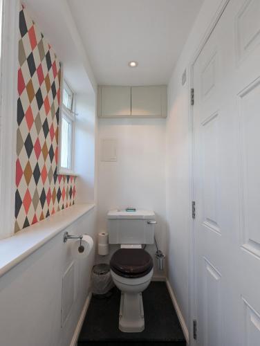a bathroom with a toilet with a brown seat at The Dulwich in Cheltenham