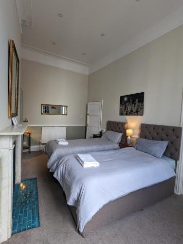a bedroom with two beds and a fireplace at The Dulwich in Cheltenham