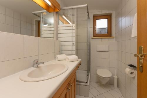 a white bathroom with a sink and a toilet at Appartement Berggasse by Schladming-Appartements in Schladming