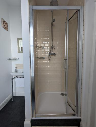 a shower with a glass door in a bathroom at The Dulwich in Cheltenham