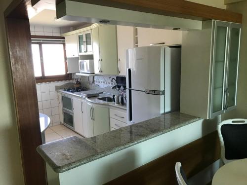 a kitchen with a refrigerator and a sink at Vista Inacreditável Por do SOL in Tramandaí