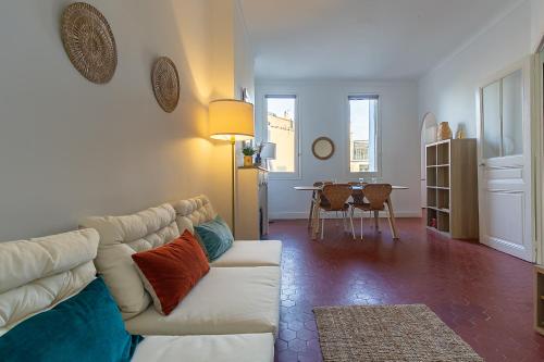 un salon avec un canapé blanc et une table dans l'établissement Appartement lumineux et central Vieux-Port, Opéra, à Marseille