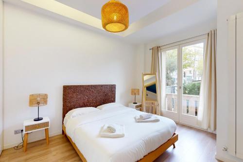 a bedroom with a large white bed and a window at Loft Victor Hugo 73 Fshh in Nice