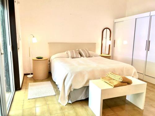 Un dormitorio con una gran cama blanca y una mesa en Beautiful Chalet Punta del Este en Punta del Este
