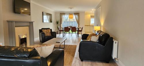 a living room with two leather couches and a table at Bunratty west Townhouse in Bunratty