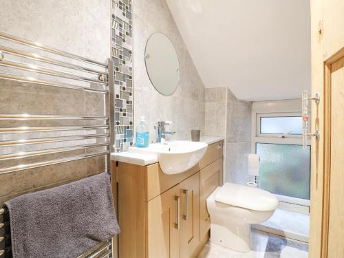 a bathroom with a sink and a toilet and a mirror at Yew Tree Cottage in Chesterfield