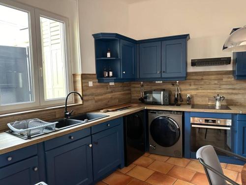 - une cuisine bleue avec un évier et un lave-vaisselle dans l'établissement Le Sept, à Alès