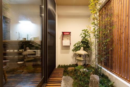 a small garden with a fire hydrant on the side of a building at 静響の宿 Silent Echo Inn in Osaka